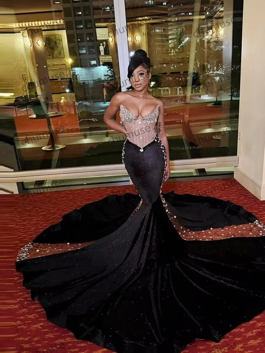 فستان سهرة أسود لامع من المخمل بتصميم حورية البحر، بفتحة رقبة على شكل قلب، وذيل طويل من الخرز 