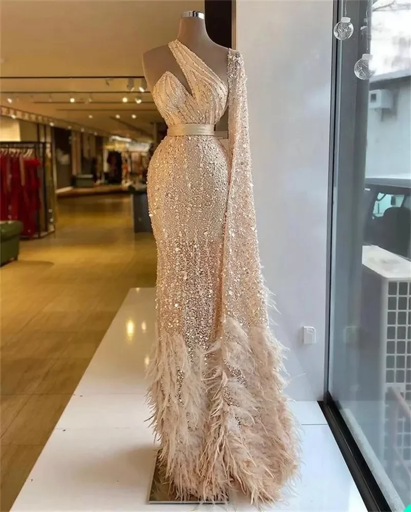 فساتين سهرة فاخرة باللون الشمبانيا حورية البحر العربية دبي مزينة بالترتر والخرز وكتف واحد وأكمام طويلة من الريش